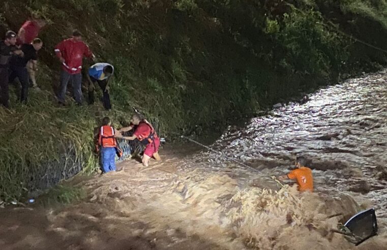 Carro com duas pessoas cai em córrego durante chuva, morador tenta ajudar e os três são resgatados pelos bombeiros em Lins